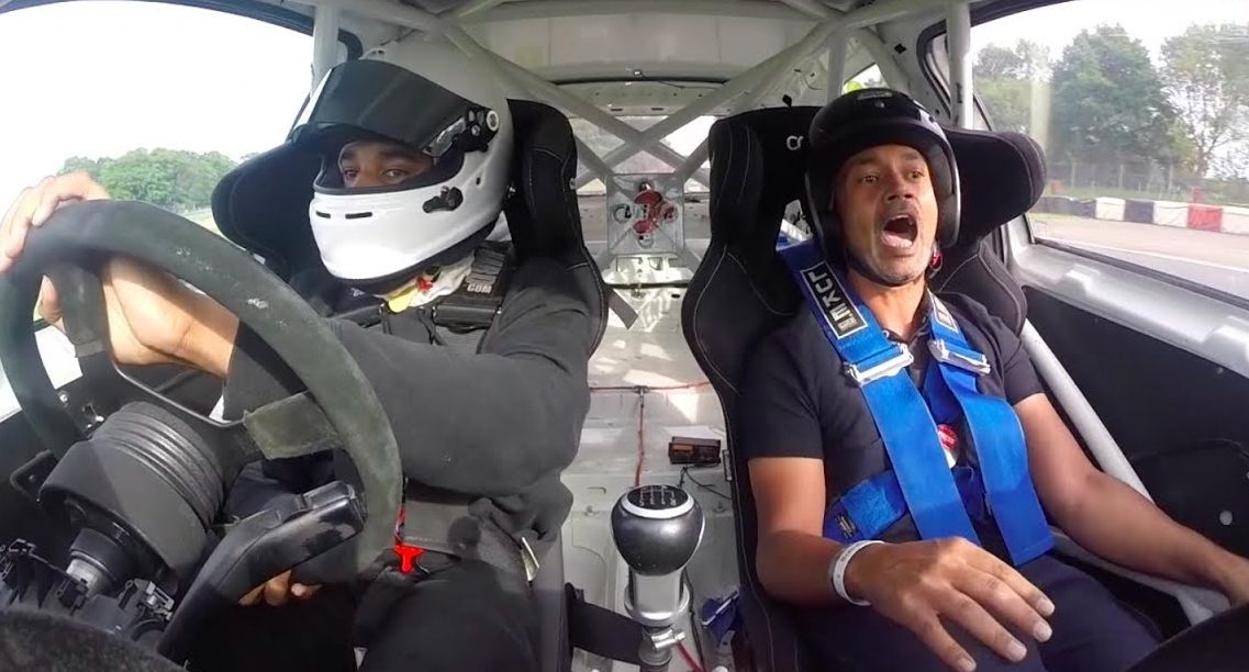 A driver and passenger in a racecar